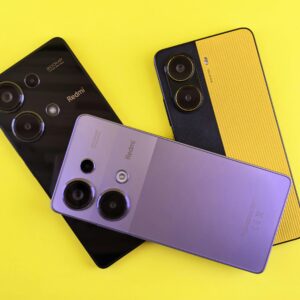 Three modern smartphones arranged creatively on a vivid yellow backdrop, showcasing sleek design and colors.