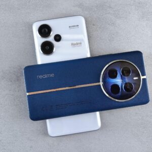 Close-up view of Realme and Redmi smartphones placed on a grey textured surface, showcasing modern technology design.