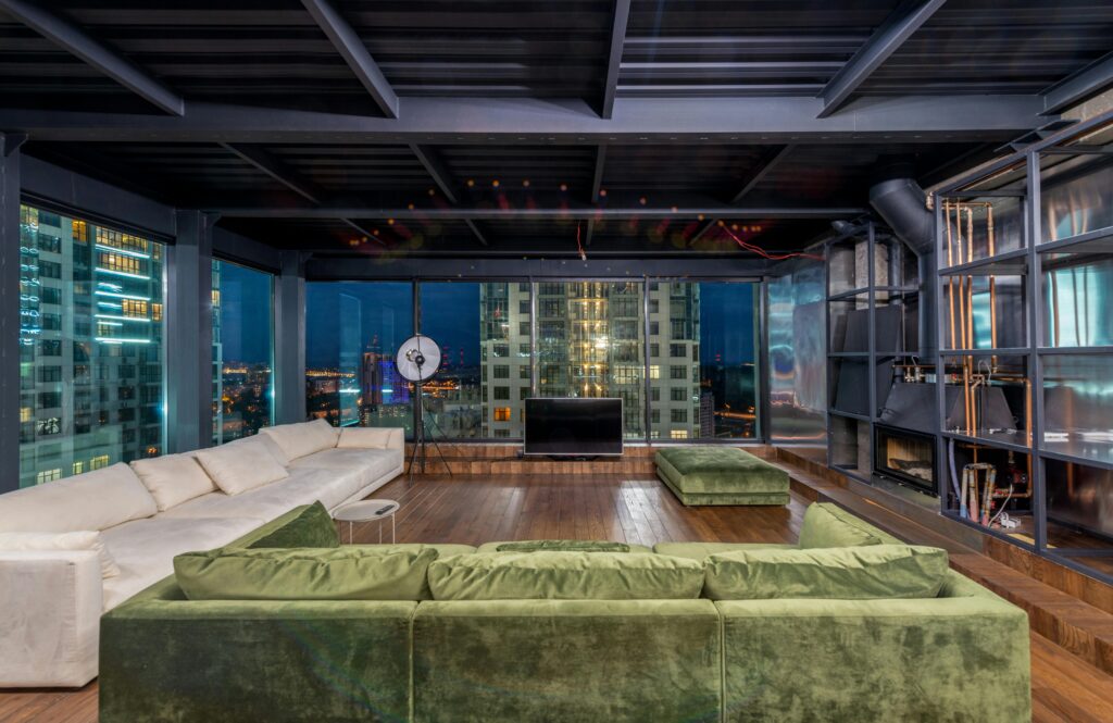Spacious modern loft with luxury decor and panoramic city views at night.